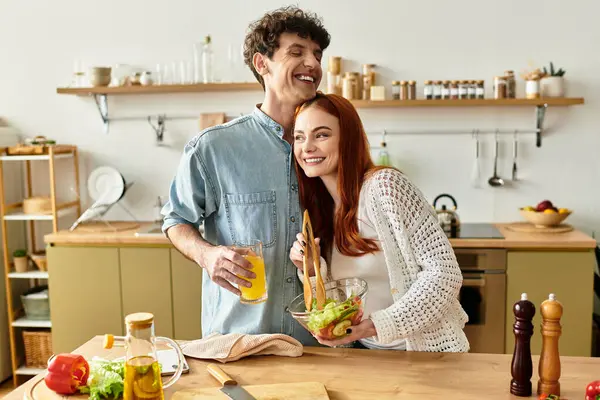 Cheerful duo shares laughter and love while cooking a fresh salad in their inviting kitchen space. — Stock Photo