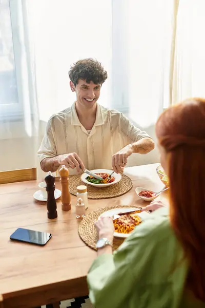 In a cozy setting, a young couple enjoys a delightful meal, savoring their time together. — Stock Photo