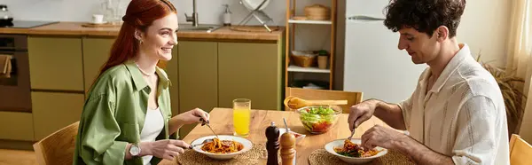 На уютной кухне, пара улыбок, наслаждаясь вкусной едой и создавая заветные воспоминания. — стоковое фото