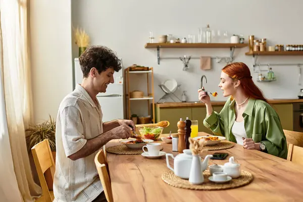 Young couple enjoys a cozy meal in their kitchen, celebrating love and togetherness. — Stock Photo