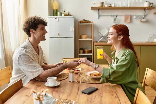 A young couple enjoys quality time together at breakfast, bonding over shared food and laughter. — Stock Photo