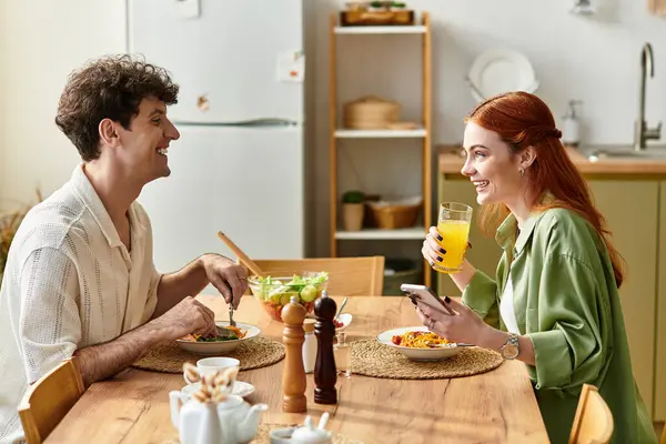 Loving couple enjoys a delightful meal at home, sharing stories and laughter over food. — Stock Photo