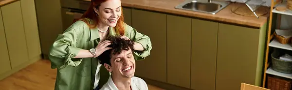 A young couple enjoys quality time together in their cozy kitchen, sharing laughter and affection. — Stock Photo