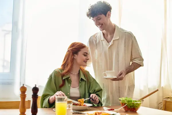 Loving couple shares a delightful meal at home, exchanging smiles and affectionate glances. — Stock Photo