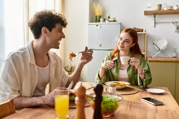 Loving pair sits at a well set table, savoring delicious food and quality time together. — Stock Photo