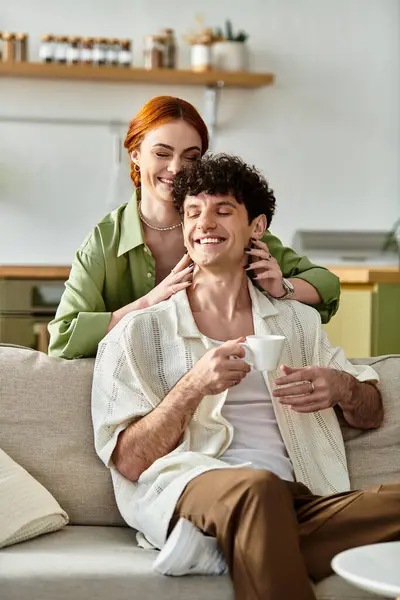 Gioiosa coppia condivide risate e affetto nel loro invitante spazio di vita sopra bevande calde. — Foto stock