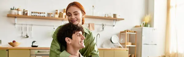 Una coppia amorevole condivide un caldo abbraccio mentre ride e si connette nella loro invitante cucina di casa. — Foto stock