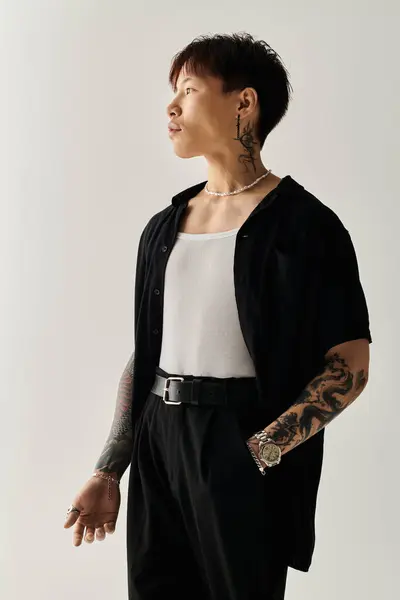 A young handsome Asian man stands confidently, exuding style in a minimalist studio. — Stock Photo