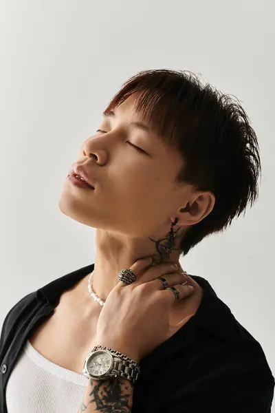 A stylish young Asian man poses confidently, showcasing his unique look and accessories. — Stock Photo