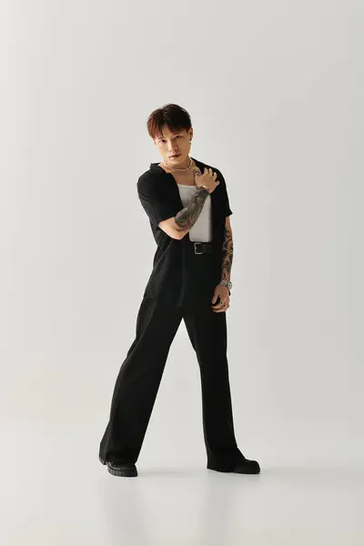 Ein junger gutaussehender asiatischer Mann steht elegant in lässiger, aber stilvoller Kleidung und strahlt Zuversicht aus. — Stockfoto