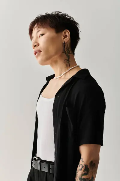 Charming young Asian man showcases his fashion sense with a trendy outfit and striking accessories. — Stock Photo