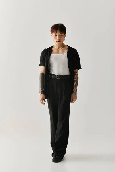 A stylish young Asian man stands confidently in a chic, minimalist space. — Stock Photo