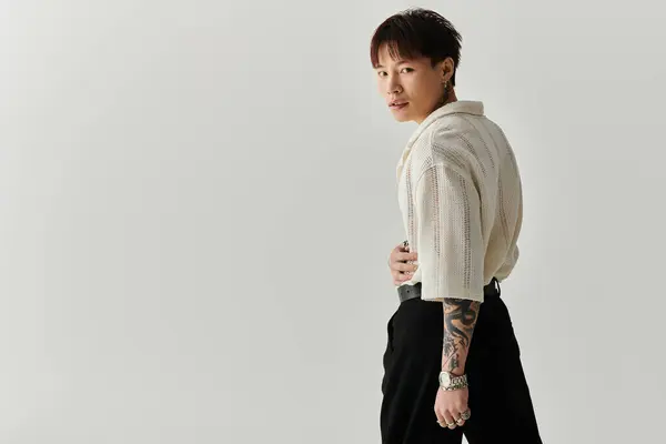 Fashionable young Asian man showcases his style in a minimalist setting, exuding confidence. — Stock Photo