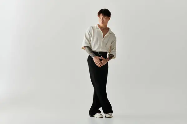 A stylish young Asian man poses confidently in a minimalist setting, radiating charm. — Stock Photo