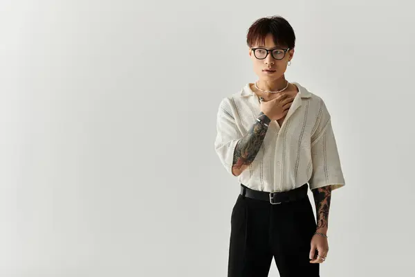 A young, handsome Asian man confidently poses in a minimal studio, showcasing his style. — Stock Photo