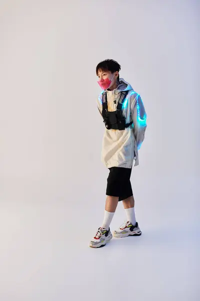 A stylish Asian man walks confidently in a modern outfit with vibrant accessories. — Stock Photo