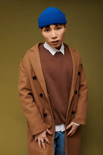 A young, handsome Asian man confidently showcases his unique fashion in an artistic setting. — Stock Photo