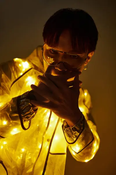 A young handsome man radiates confidence in a stylish illuminated outfit at an energetic gathering. — Stock Photo