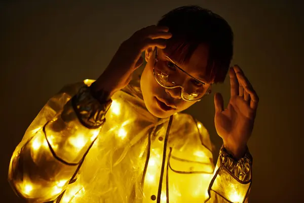 A young Asian man displays a unique fashion sense, glowing softly in the light. — Stock Photo