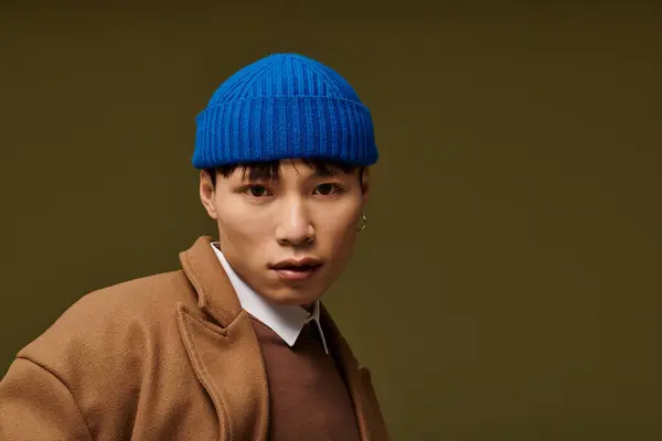 A young Asian man dressed in a stylish outfit poses confidently, showcasing contemporary fashion. — Stock Photo
