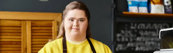 In a vibrant cafe, a young woman with Down syndrome confidently engages in her surroundings. — Stock Photo