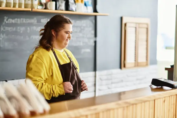 A young woman with Down syndrome showcases confidence and warmth at a busy cafe. — Stock Photo