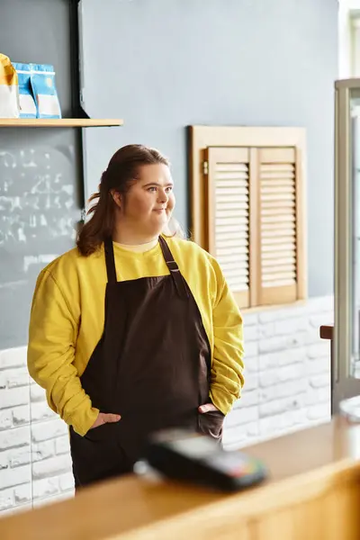 A young woman with Down syndrome confidently poses in a cafe, wearing casual attire. — Stock Photo