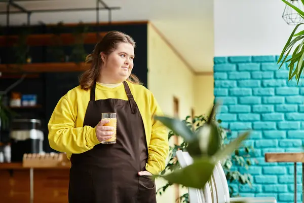 A confident young woman with Down syndrome enjoys a drink in a vibrant cafe. — Stock Photo
