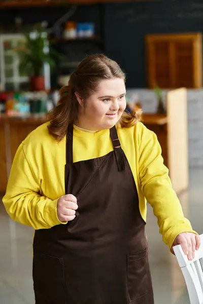 In a lively cafe, a young woman with Down syndrome confidently interacts, dressed casually. — Stock Photo