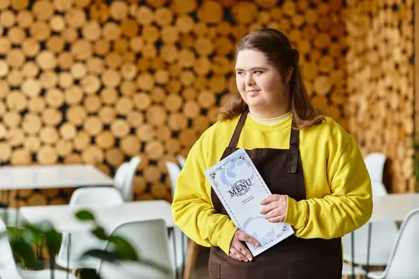 Young woman with Down syndrome confidently showcases the menu in a vibrant cafe. — Stock Photo