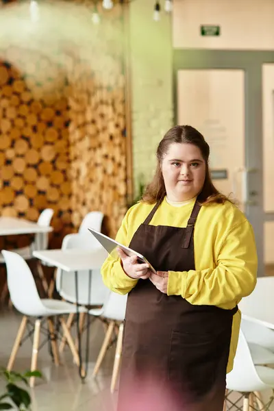 En un café alegre, una joven con síndrome de Down muestra su fuerte presencia, lista para el día. - foto de stock