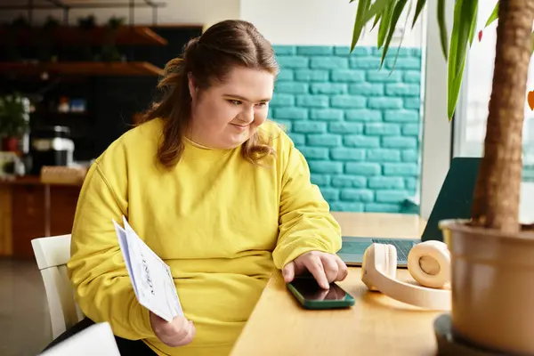 A confident young woman with Down syndrome relaxes at a cafe, enjoying her smartphone. — Stock Photo