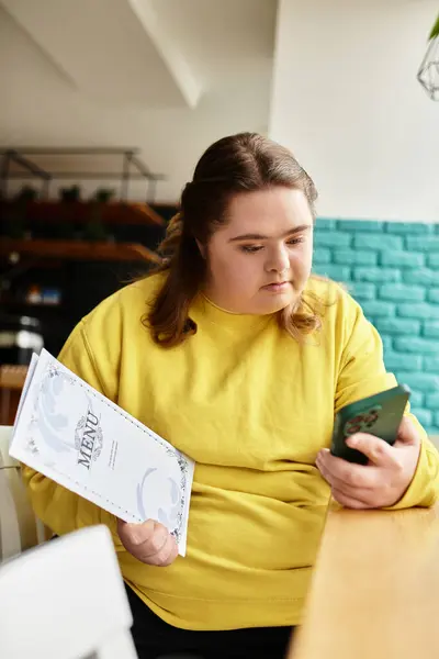 In a vibrant cafe, a confident young woman with Down syndrome studies the menu in casual wear. — Stock Photo