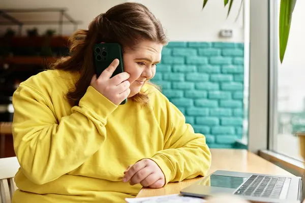Young woman with Down syndrome chats on the phone while sitting at a cafe. — Stock Photo