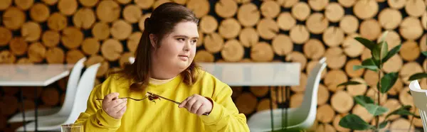 In a cozy cafe, a confident young woman with Down syndrome enjoys her dessert. — Stock Photo