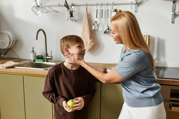 A warm interaction unfolds as a mother and her son bond over cooking, filled with laughter and joy. — Stock Photo