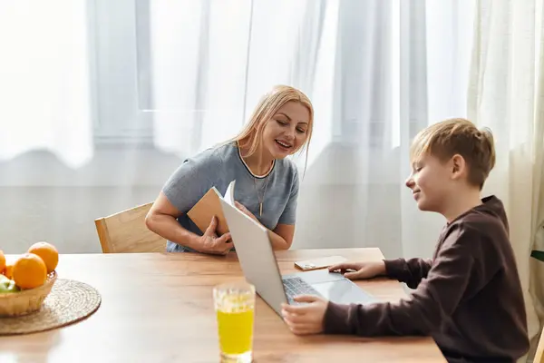 A mother and son engage in an interactive learning session at their dining table. — Stock Photo