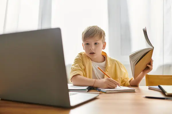 A little cute boy in comfy casual attire engages with his laptop while studying at home. — Stock Photo