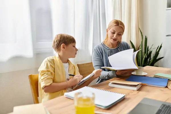 Mother and son engage in a meaningful study session, sharing knowledge and laughter at home. — Stock Photo