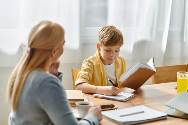 Una madre y su hijo comparten una tarde acogedora, participando en un estudio tranquilo y vinculándose sobre el aprendizaje. - foto de stock