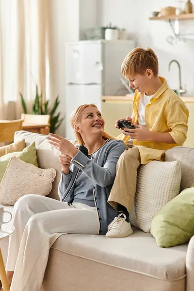 Una madre condivide un momento giocoso con suo figlio su un comodo divano pieno di cuscini. — Foto stock