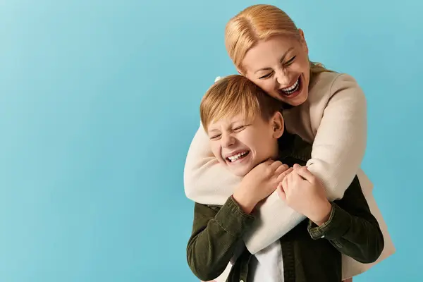 In a joyful setting, a woman and her son laugh together, showcasing their deep bond. — Stock Photo