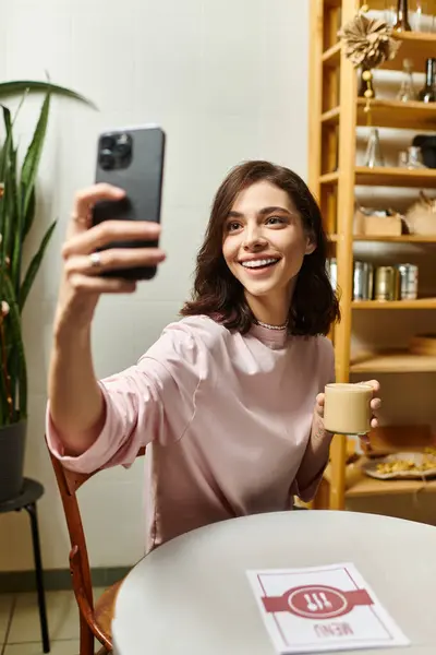 A young woman with a bright smile captures a joyful moment while enjoying coffee. — Stock Photo