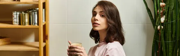 En un café sereno, una hermosa joven saborea su bebida mientras se pierde en el pensamiento, pancarta — Stock Photo