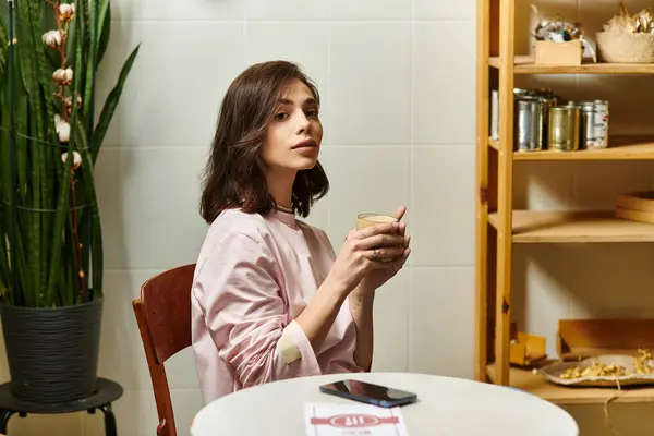 Una joven disfruta de su bebida en un elegante café, capturando la esencia de la vida urbana. - foto de stock