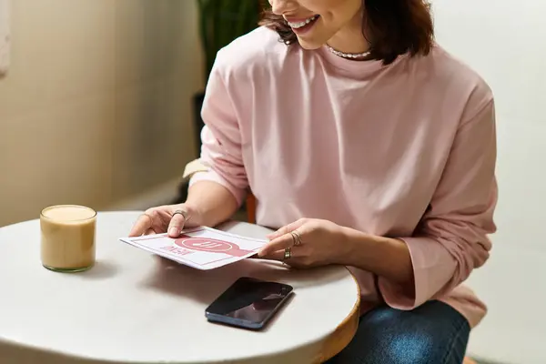 Bella giovane donna in un caffè moderno si rilassa con il caffè mentre recensisce il menu. — Foto stock