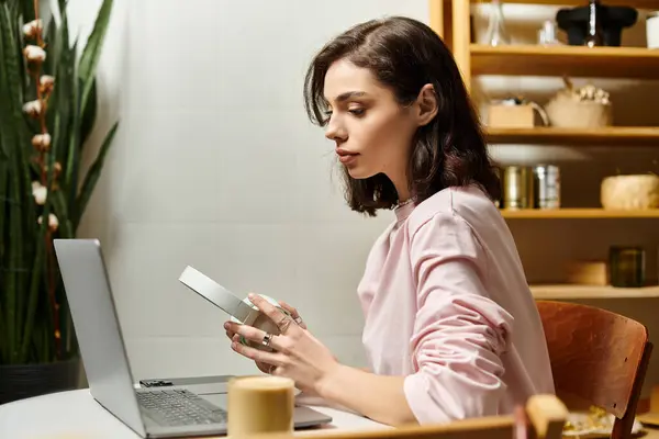 Young woman focuses on her tasks while enjoying a relaxed atmosphere in a modern cafe. — Stock Photo