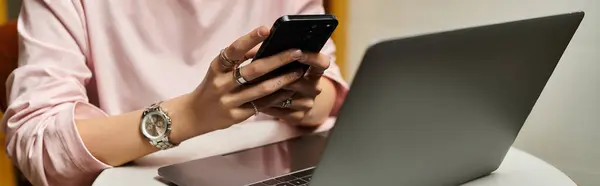 Young woman working on a laptop while texting in a bright modern cafe setting, banner — Stock Photo