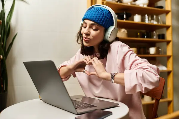 A young woman is happily engaged in remote work at a modern cafe, expressing her creativity. — Stock Photo