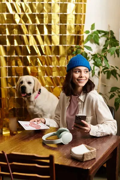 A young woman smiles while seated at a table with her labrador, enjoying a relaxed cafe atmosphere. — Stock Photo
